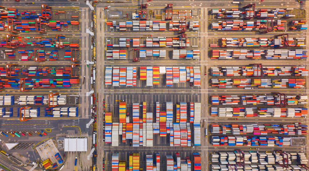 城市进出口业务和物流国际货物中集装箱货船的空中俯视图在香港维多利亚港用起重机运送到港口
